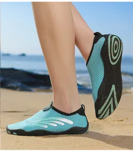 Vue détaillée de chaussures aquatiques vert menthe respirantes sur une plage de sable