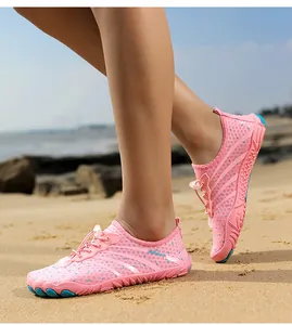 Detailed macro shot of pink breathable quick-dry water shoes worn on a sandy beach