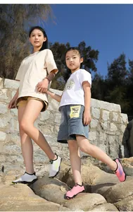 Adulte et enfant portant des chaussures d'eau respirantes sur des rochers au soleil