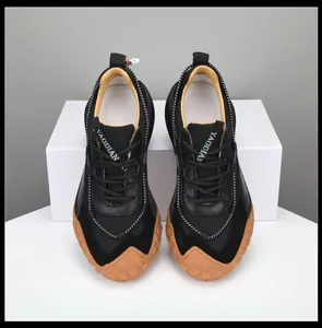Vista dall'alto di sneakers in pelle premium nere con suola in gomma per stile casual.