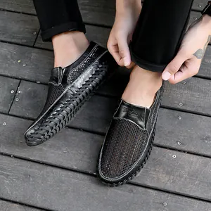 Detailopname van zwarte ademende leren herenschoenen met een verfijnde gevlochten zijtextuur.