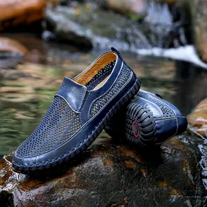 Detailopname van ademende blauwe mesh herenloafers op natuurlijke natte rivierrotsen