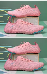Pink quick-dry water shoes with breathable mesh and toggle laces on a decorative prop.