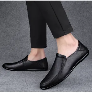 Side view of black soft leather slip-on loafers on feet with professional grey background