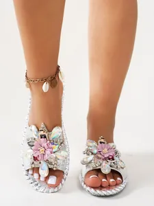Vue détaillée de sandales plates argentées style français avec strass et fleurs mauves.