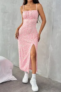 Detailed view of a pink summer midi dress with daisy print and high side slit