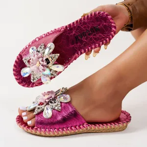 Vue détaillée des mules métallisées fuchsia avec fleurs en strass et semelle tressée