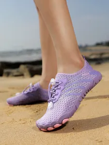 Purple quick-drying outdoor water shoes with breathable mesh shown on a sandy beach