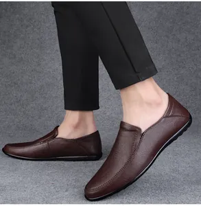 Close-up detail of men's brown soft leather loafers worn with black dress pants