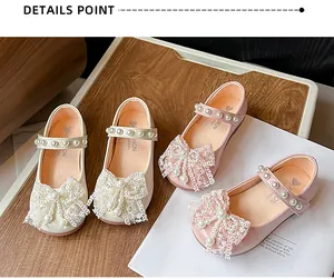 Macro detail of sweet girls' princess shoes with lace bows and pearl straps.