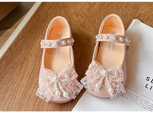 Detailed view of pink girls' princess shoes with lace bows and pearl accents