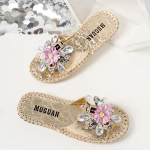 Vue détaillée de sandales plates dorées style français avec de grandes fleurs en strass.