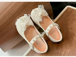 Detailed view of cream girls' princess shoes featuring lace bow and pearl accents.