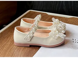 Elegant cream girls' princess shoes with intricate lace bow and pearl detailing