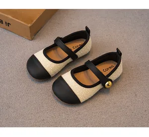 Detaillierte Nahaufnahme von Mädchen-Mary Janes aus beigem Tweed mit schwarzer Kappe