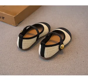 Nahaufnahme von Mädchenschuhen im Mori-Stil mit Strukturstoff und Goldknopf.