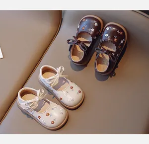 Vue détaillée de chaussures Mary Jane à broderies florales pour filles, marron et beige.