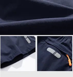 Dettaglio dei pantaloncini sportivi blu navy con trama del tessuto e inserti riflettenti.