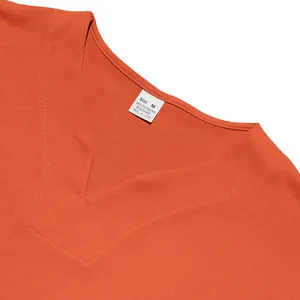 Detailed macro view of an orange men's V-neck jersey collar with its material label