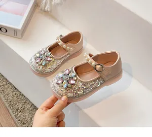 Gros plan de chaussures Mary Jane roses scintillantes pour filles avec fleur en cristal.