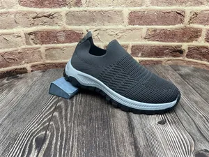 Vista lateral de zapatilla casual gris para hombre en tejido transpirable con suela blanca