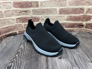 Detalle de zapatillas slip-on de flyknit negro con malla transpirable y suela blanda.