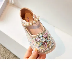 Gros plan détaillé de chaussures de princesse roses pailletées pour filles avec fleur en strass.