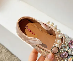 Détail d'une chaussure de princesse étincelante pour filles avec perles et strass.