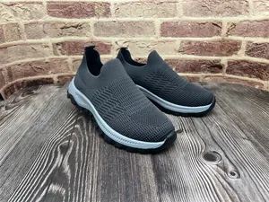 Vista lateral de zapatillas de punto gris oscuro sin cordones sobre madera.