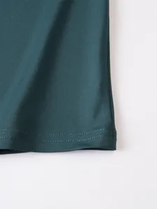 Detaillierte Nahaufnahme des doppelt genähten Saums eines dunkelgrünen Sport-Tanktops