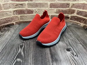 Detalle de zapatos slip-on de punto rojo para hombre con suela de goma gris suave.