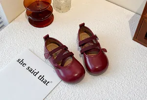 Detailed macro view of dark red girls' leather Mary Jane shoes featuring elastic straps