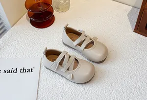 Close-up view of beige children's Mary Jane shoes with triple elastic straps on top