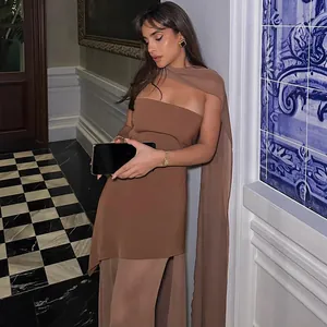 Elegant brown strapless dress with mesh scarf neck detail worn by fashion model in hallway