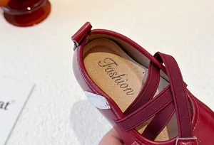 Close-up detail of girls' burgundy Mary Jane shoe with elastic straps