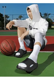 Stylische schwarze Herren-Sport-Sandalen, getragen auf einem sonnigen Basketballplatz