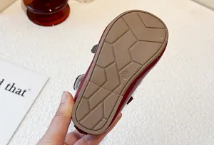 Close-up detail of the non-slip soft rubber sole on these red girl's princess leather shoes