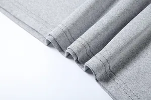 Detailed close-up of grey fabric texture and double-stitched hem on a slim-fit garment