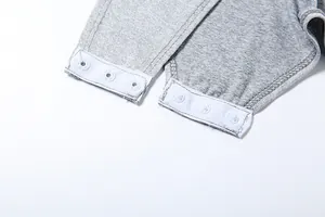 Close-up detail of grey bodysuit featuring bottom snap button closure for easy wear