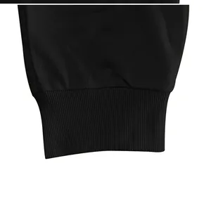 Dettaglio dei polsini a costine sui pantaloni da jogging in cotone nero da uomo.