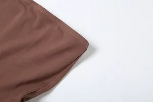 Close-up detail of high-quality double-stitched hem on brown stretch fabric dress