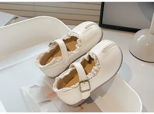 Primer plano de los zapatos de princesa estilo Tabi para niña con encaje delicado y cuero suave