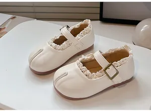 Vista detallada de zapatos Mary Jane blancos con encaje y diseño de punta dividida