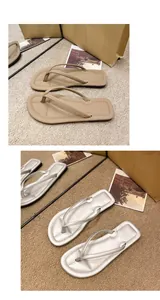 Detailansicht von modischen flachen Zehentrenner-Sandalen in Hellbraun und Silber
