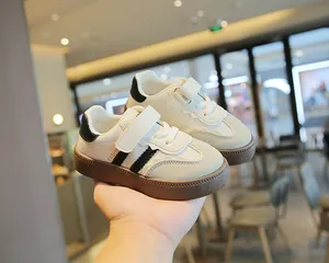 Detailansicht cremefarbener Kindersneaker mit schwarzen Streifen und brauner Sohle