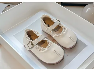 Vista detallada de zapatos Mary Jane Tabi para niña en crema con encaje y suelas blandas