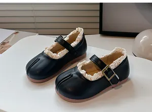 Primer plano de zapatos Tabi Mary Jane negros para niñas con delicado borde de encaje