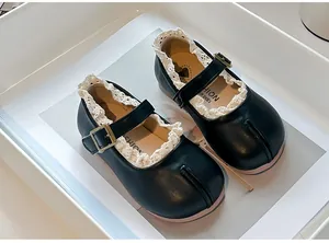 Detalle de Mary Janes Tabi negras para niña con ribete de encaje y suela blanda.