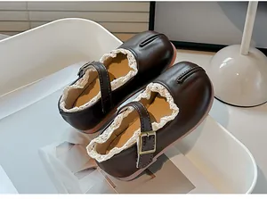Vista detallada de zapatos de cuero marrón oscuro para niña con ribete de encaje