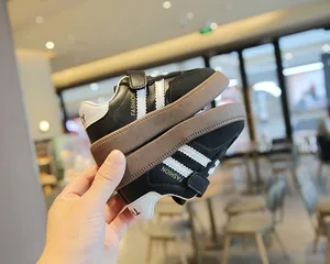 Schwarze Kinder Sneaker im deutschen Trainer-Stil mit klassischen weißen Streifen